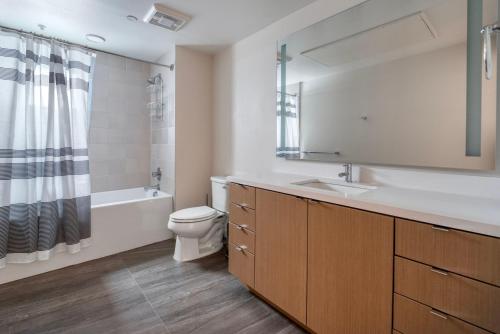 La salle de bains est pourvue d'un lavabo, de toilettes et d'un miroir. dans l'établissement Oakland 2br w lounge bbq nr restaurants SFO-1493, à Oakland