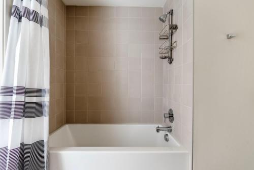 a bath tub in a bathroom with a shower curtain at Oakland 1br w gym ac nr bart nightlife SFO-1492 in Oakland