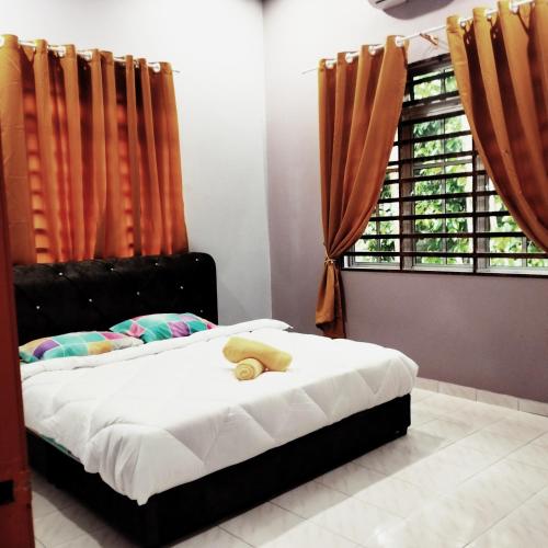 Ένα ή περισσότερα κρεβάτια σε δωμάτιο στο Rezqrich Villa Homestay 2