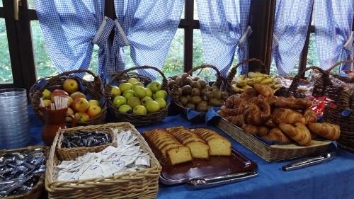 a table with baskets of fruit and bread on it at Conjunto Hotelero La Pasera in Soto de Cangas
