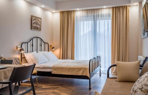グダウリにあるNew Gudauri Neo Apartment 306のベッドと大きな窓が備わるホテルルームです。