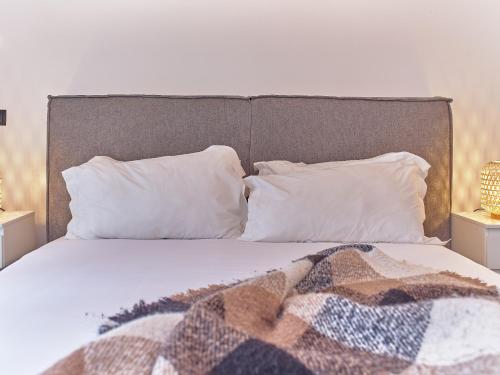 a bed with white pillows and a blanket on it at TheCasaEdition Gauthier Residency City Center in Casablanca