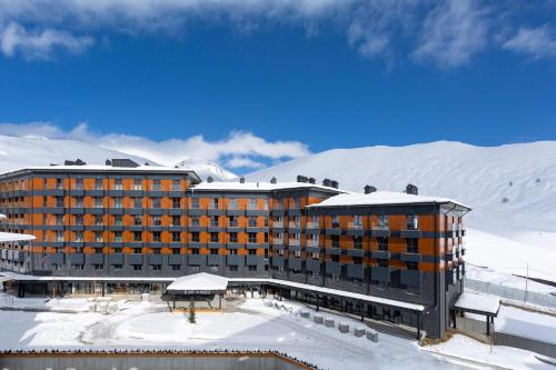 een hotel in de sneeuw met besneeuwde bergen bij Luxury Apartments With Mountain View in Neo New Gudauri in Goedaoeri