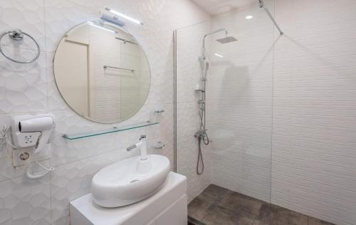Baño blanco con lavabo y espejo en New Gudauri Neo Apartment 306, en Gudauri
