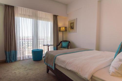 a hotel room with a bed and a window at Arkin Palm Beach Hotel in Mağusa