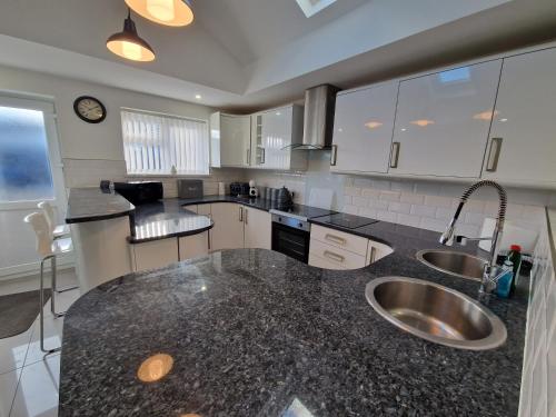 a kitchen with a sink and a counter top at Comfortable 3 Bed home Merthyr Tydfil near Bike Park Wales & Brecon Beacons in Dowlais
