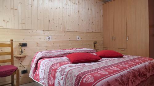 a bedroom with a bed with red pillows at La Petite Maison in Aosta