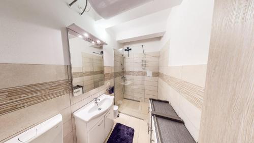 Un baño blanco con lavabo e inodoro. en Chaplin Apartment - Free Garage Parking, en Liubliana