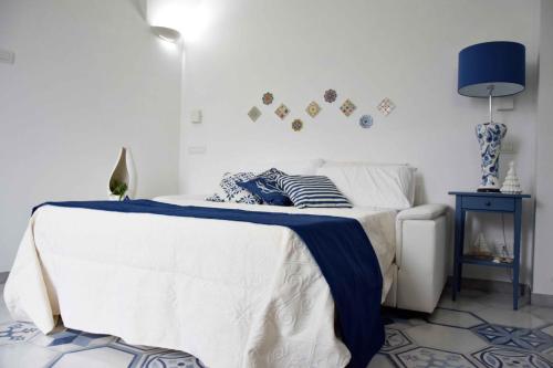 a bedroom with a bed with a blue blanket on it at Mela & Cannella accommodation in Minori