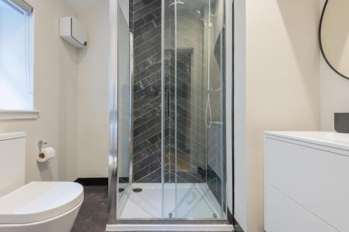 a glass shower in a bathroom with a toilet at Priorsgate in St. Andrews