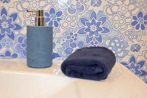 a black towel sitting next to a vase on a sink at Mela & Cannella accommodation in Minori