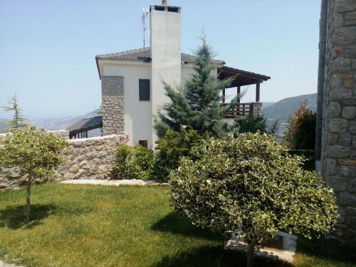 a house with trees in front of a building at Guesthouse Diochri in Kato Trikala Korinthias
