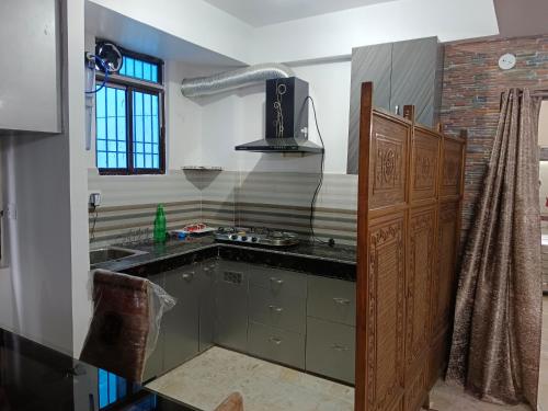 a kitchen with a sink and a stove at Eastern guest house in Patna