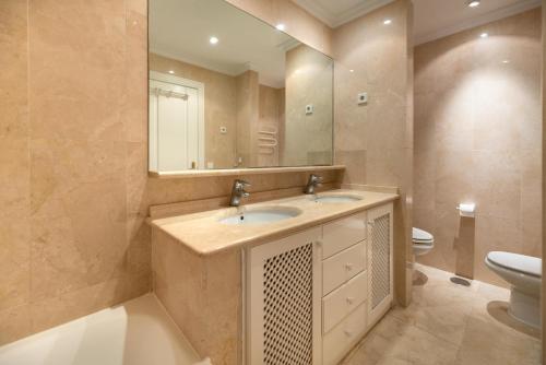 bagno con lavandino, servizi igienici e specchio di HomeForGuest beach apartment in Puerto Banus Marbella a Marbella