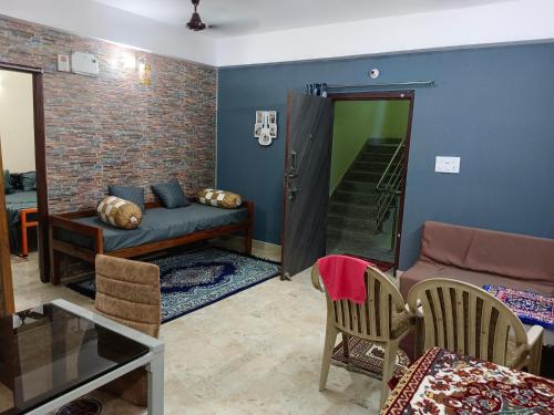 sala de estar con sofá, mesa y sillas en Eastern guest house en Patna