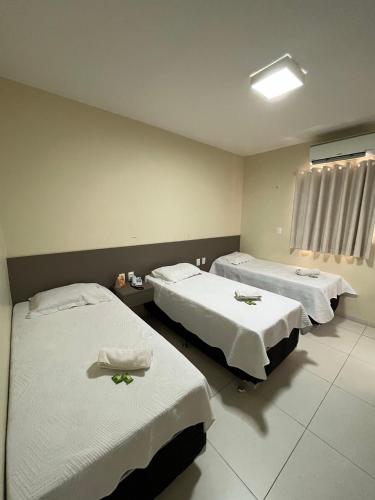 a hotel room with two beds with white sheets at SD Plaza Hotel in Sobral