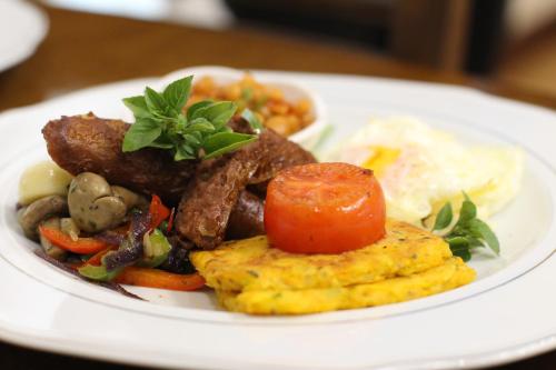 a plate of food with meat and vegetables on a table at Malabi Exclusive Lodges in Lilongwe