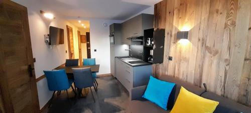 - une cuisine avec une table et des chaises bleues dans la chambre dans l'établissement BILLY - AVORIAZ Les INTRETS 2 - 5pers. - 2 chambres - 30 m2 -1 SDB, à Morzine