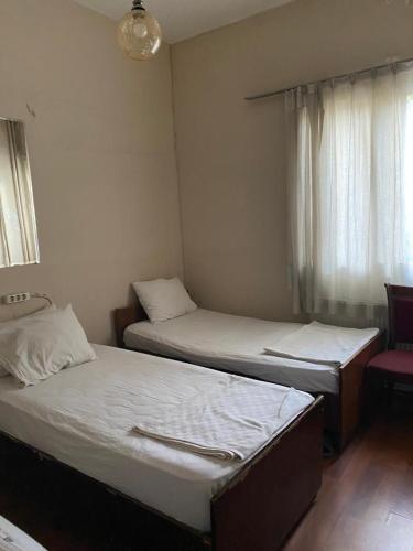 two twin beds in a room with a window at otel ova in Konak