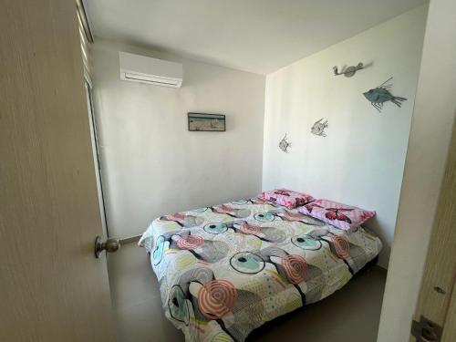 Dormitorio pequeño con cama y edredón colorido en Melody s private apartment, en Cartagena de Indias