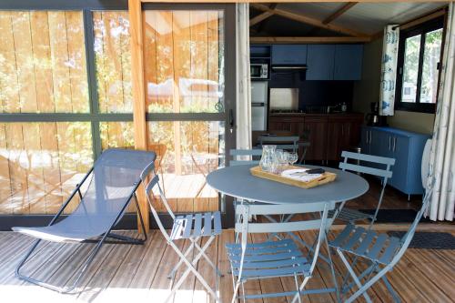 una mesa y sillas en una habitación con cocina en Huttopia Parque de Doñana, en Hinojos