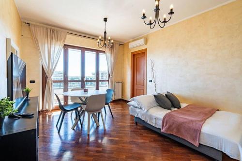 1 dormitorio con 1 cama y 1 mesa con sillas en Perugino's Peaceful Sky Terrace en Ponte Galeria