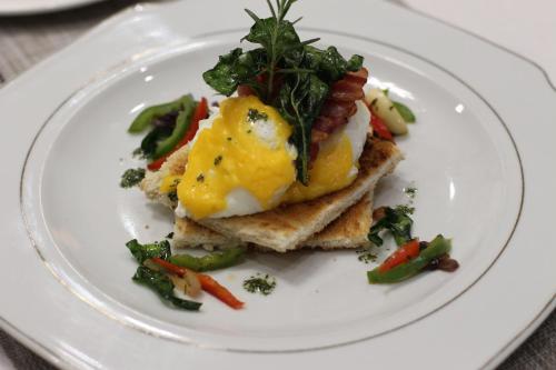 a plate of food with eggs on top of toast at Malabi Exclusive Lodges in Lilongwe