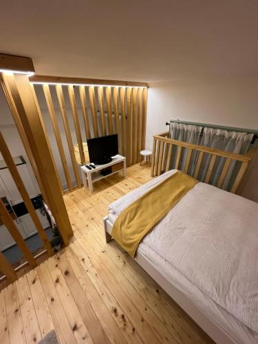 a bedroom with a bed and a flat screen tv at Bocskai Apartman in Szeged