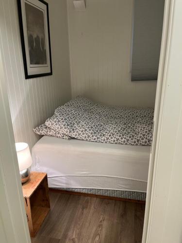 a small bedroom with a bed and a table at Gimle cozy apartment in Tromsø