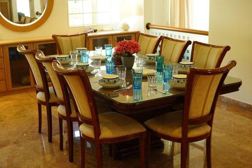 mesa de comedor con sillas y mesa con gafas azules en White House BEACH Executive Residence en Tanjung Bungah