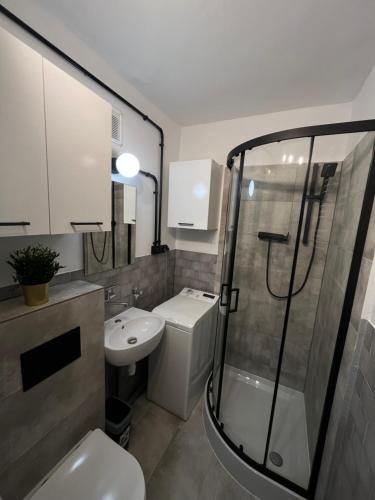 e bagno con servizi igienici, lavandino e doccia. di Murano Apartaments Promenada studio a Varsavia