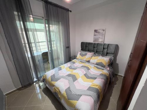 a bedroom with a bed and a large window at Kenitra Unique Design Appartment in Kenitra