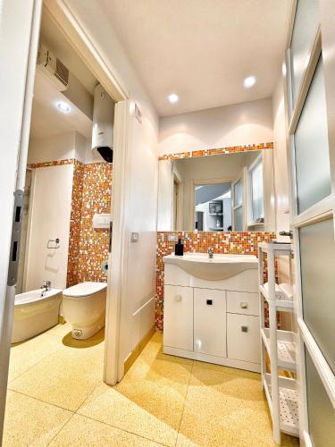 a bathroom with a toilet and a sink and a mirror at L'Appartamentino Montagna in Biella