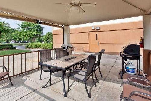 a patio with a table and chairs and a grill at Sonesta Simply Suites Orange County Airport in Santa Ana