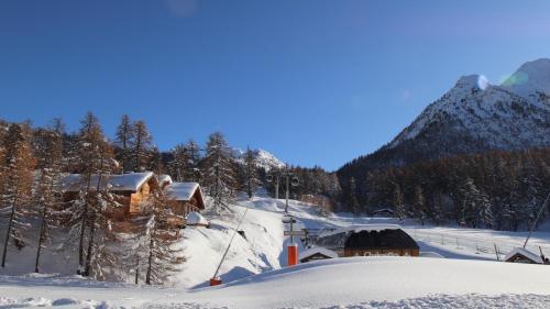モンジェネヴルにあるSlope-Side Chalet w/Jacuzzi, Home Cinema, for 16 Guestsの山を背景にした雪に覆われたキャビン