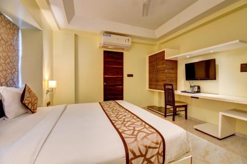 a bedroom with a large bed and a desk at Hotel Deepali Executive in Aurangabad