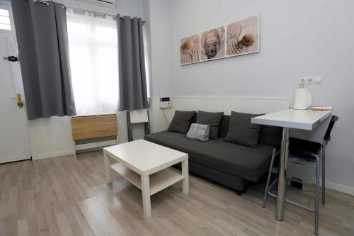 ein Wohnzimmer mit einem Sofa und einem Tisch in der Unterkunft La casita de Valvanera in Madrid