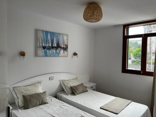 a bedroom with two beds and a window at Playa Ingles central cozy apartment in Maspalomas