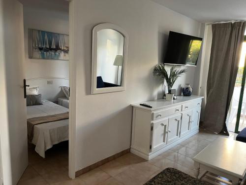 a bedroom with a white dresser and a mirror at Playa Ingles central cozy apartment in Maspalomas
