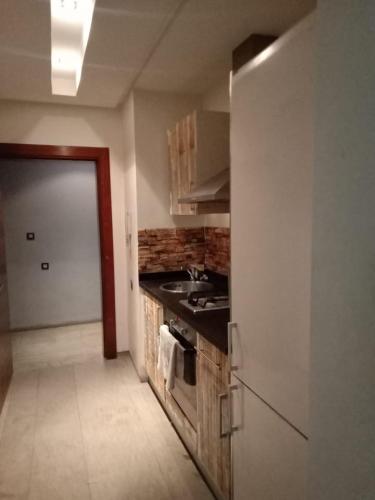 een keuken met een wastafel en een fornuis top oven bij appartement haut standing à gueliz in Marrakesh