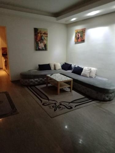 een woonkamer met een groot bed en een tafel bij appartement haut standing à gueliz in Marrakesh
