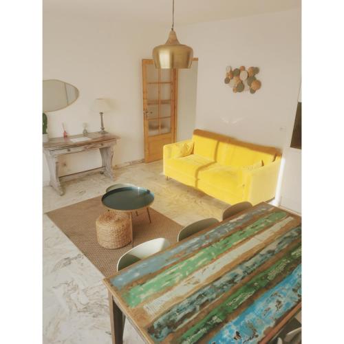 un salon avec un canapé jaune et une table dans l'établissement COTE PLAGE HYPER CENTRE - Bord de mer, au Grau-du-Roi