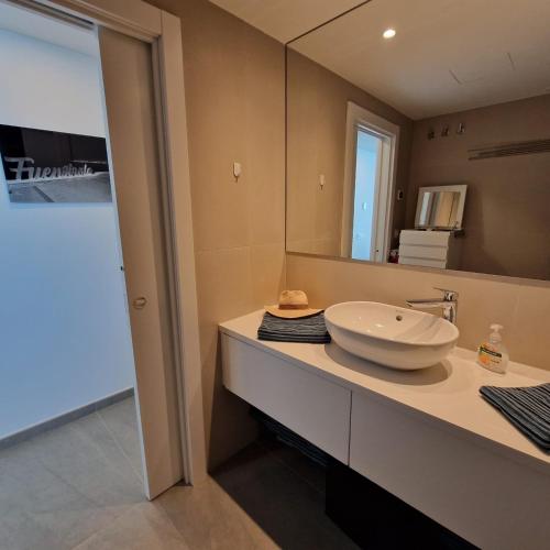 a bathroom with a sink and a large mirror at Dúplex con vistas impresionantes in Fuengirola