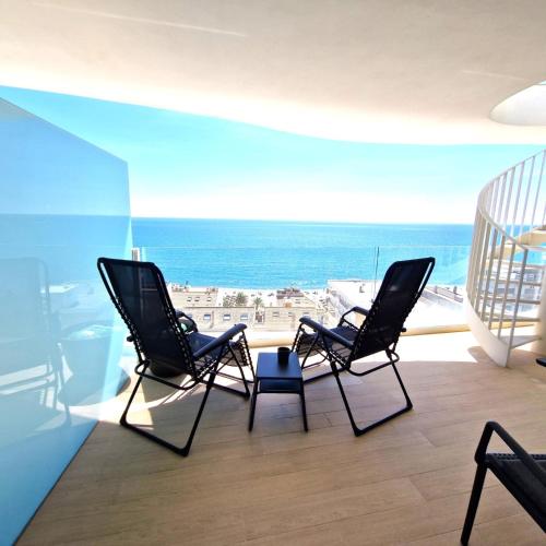 two chairs sitting on a balcony with a view of the ocean at Dúplex con vistas impresionantes in Fuengirola