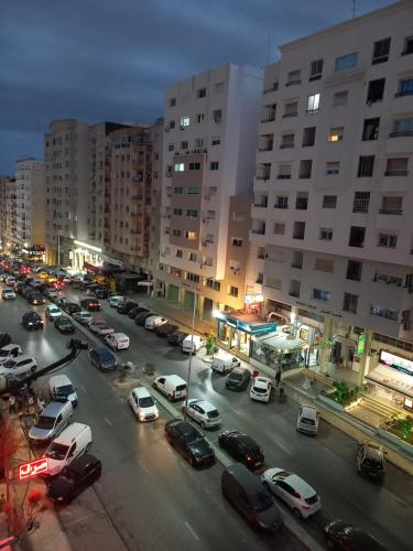 una calle de la ciudad con coches aparcados en un estacionamiento en Joli studio, 17 Avenue Hedi Nouira Ennasr 2, Ariana, Tunis, en Ariana