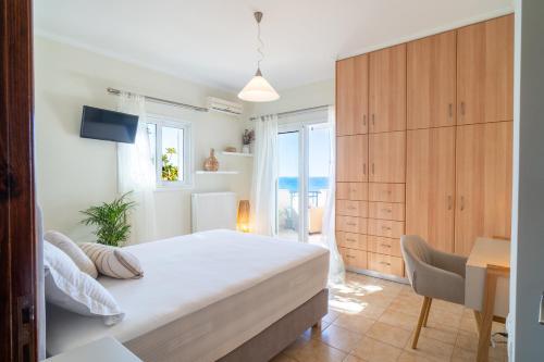 a bedroom with a bed and a table and a desk at Kondarini Villa - Stunning Sea Views, 290m from the beach, by ZanteWize in Tsilivi