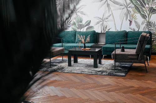 a living room with a green couch and two chairs at Royal G Max in Golem