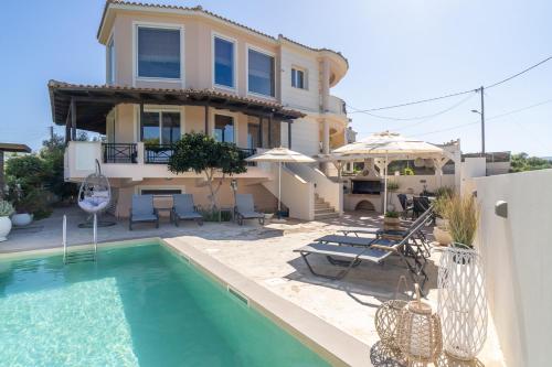 a villa with a swimming pool in front of a house at Kondarini Villa - Stunning Sea Views, 290m from the beach, by ZanteWize in Tsilivi