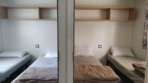 a room with two beds and a mirror at LJ Cosy Lodge - Mobilhome in Houlgate