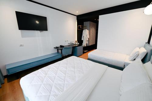 a hotel room with two beds and a flat screen tv at Royal G Max in Golem